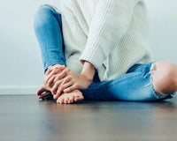 Distressed blue jeans with a white sweater.