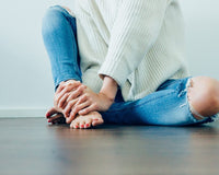 Distressed blue jeans with a white sweater.