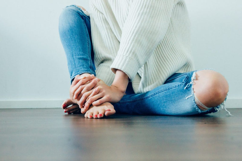 Distressed blue jeans with a white sweater.
