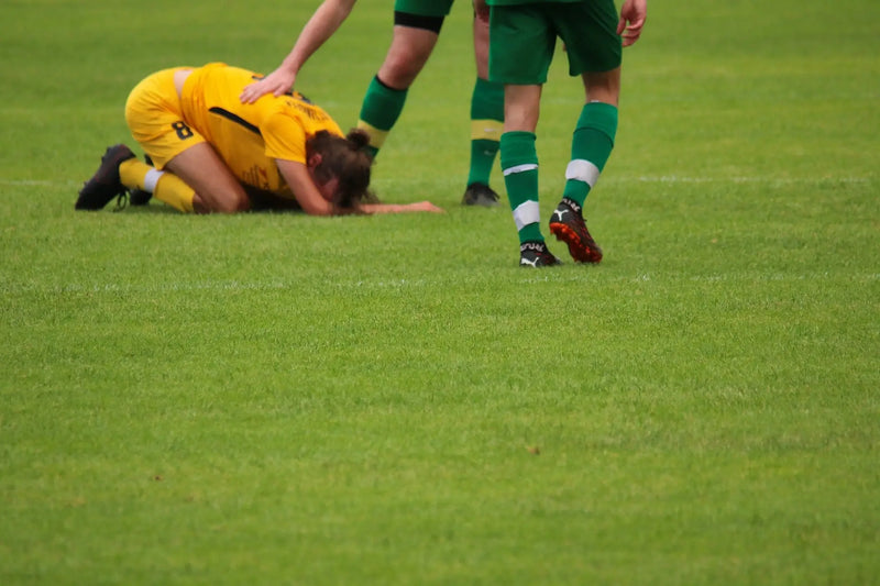 Soccer player kneeling on the field.