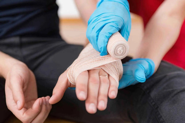 Hand being wrapped with bandage.