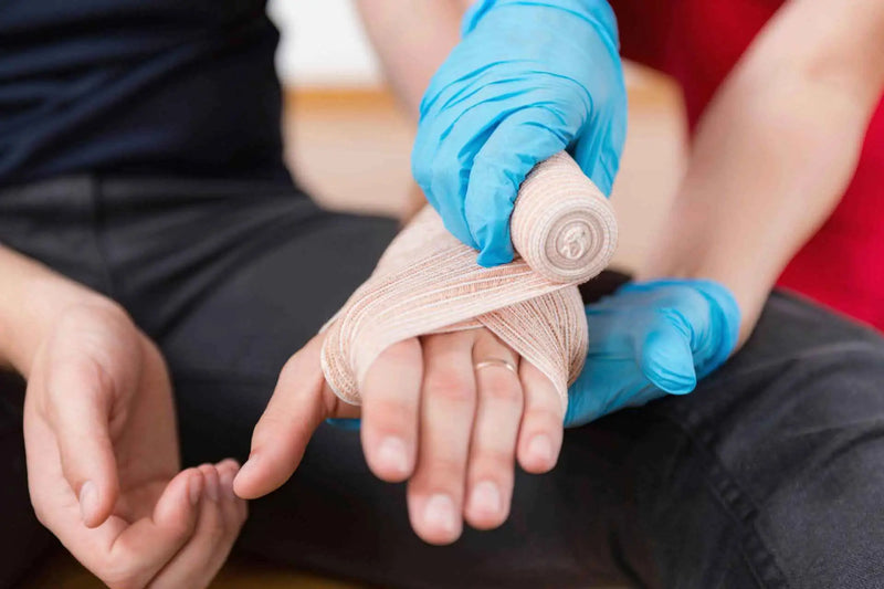 Hand being wrapped with bandage.